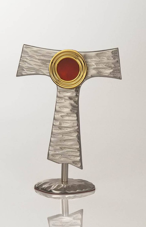 Relikwiarz mosiężny w kształcie franciszakńskiego symbolu o wysokości 20 cm
