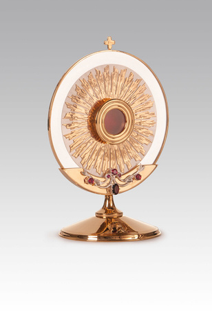 Relikwiarz mosiężny złocony w formie hostii na jedną relikwię o wysokości 37 cm